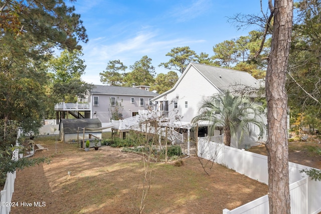 rear view of house with a deck, stairway, and fence