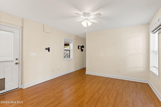 unfurnished room featuring ceiling fan, light wood finished floors, and baseboards