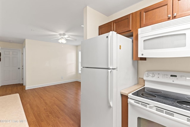 kitchen featuring white appliances, a ceiling fan, light countertops, brown cabinets, and light wood finished floors