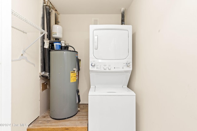 laundry room featuring stacked washer / dryer, laundry area, water heater, and light wood-style flooring