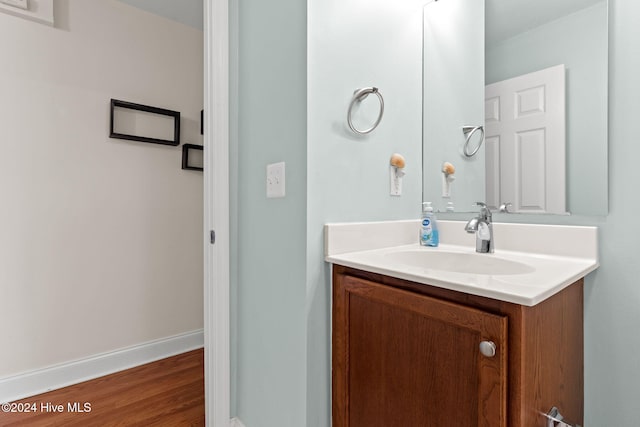 bathroom with vanity, baseboards, and wood finished floors