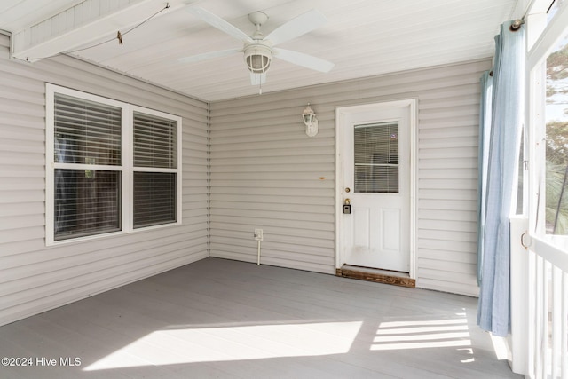 unfurnished sunroom featuring a ceiling fan