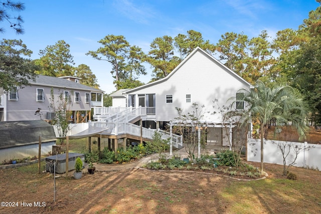 back of house with fence and a deck