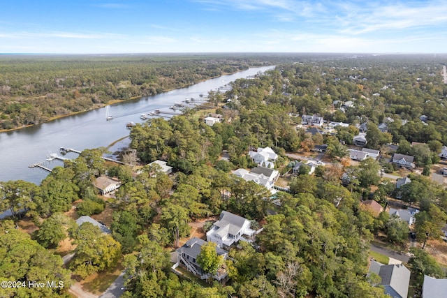 drone / aerial view featuring a residential view, a water view, and a wooded view