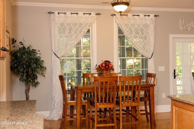 dining space with crown molding and hardwood / wood-style flooring