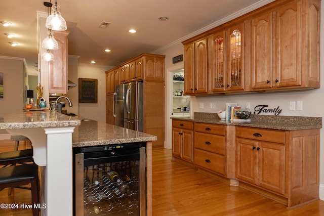 kitchen featuring kitchen peninsula, beverage cooler, a breakfast bar, light wood-type flooring, and stainless steel refrigerator