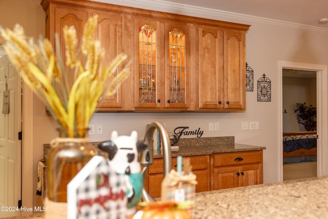 kitchen with crown molding and light stone counters