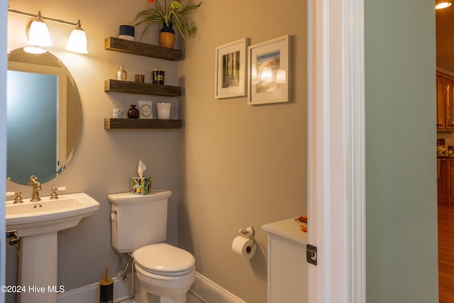 bathroom featuring toilet, hardwood / wood-style floors, and sink