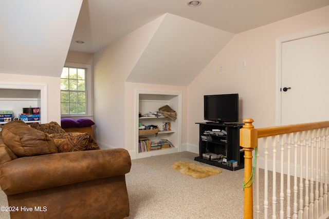 carpeted living room with vaulted ceiling and built in features