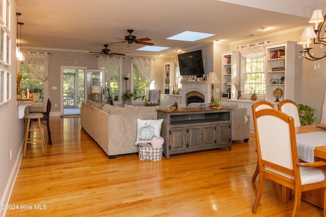 living room featuring a wealth of natural light, ornamental molding, light hardwood / wood-style flooring, and ceiling fan