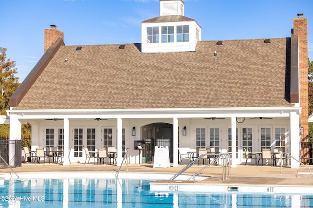 rear view of property featuring a patio area, a community pool, and ceiling fan