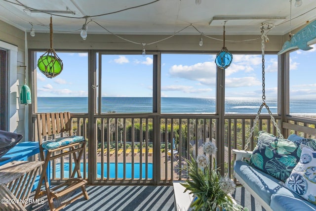 sunroom / solarium featuring a water view