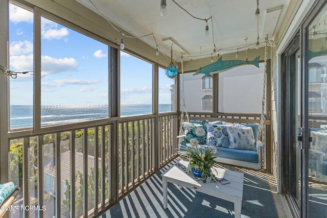 unfurnished sunroom featuring a water view