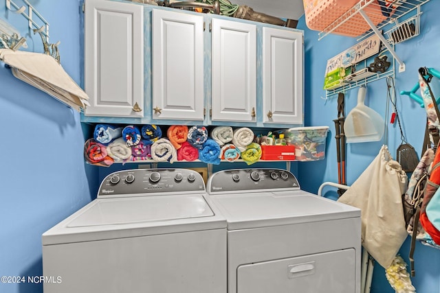 washroom featuring washing machine and dryer and cabinets