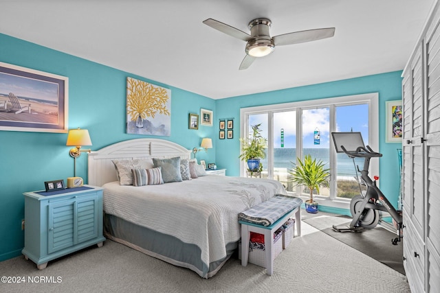 bedroom featuring a water view, carpet floors, and ceiling fan