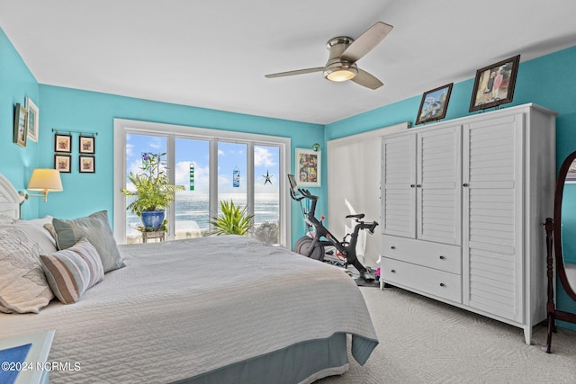 carpeted bedroom with access to outside, a water view, and ceiling fan