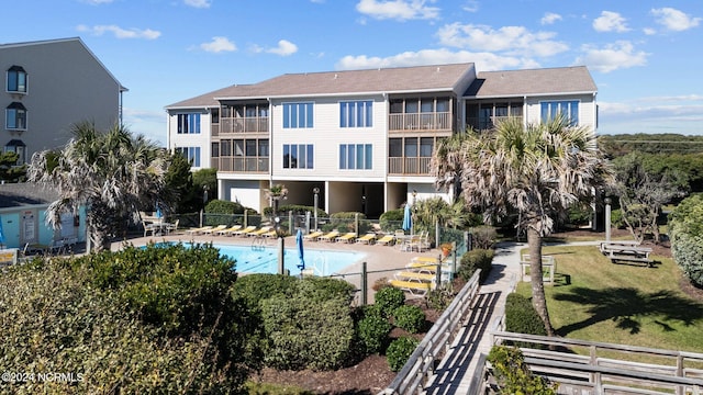 view of pool with a patio area and a lawn