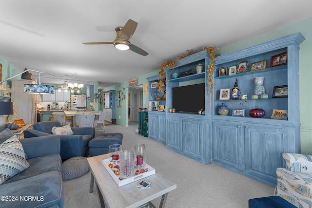 living room featuring light carpet and ceiling fan with notable chandelier