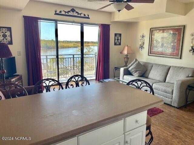 interior space with a water view, ceiling fan, and hardwood / wood-style flooring