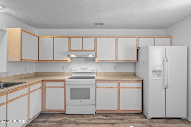 kitchen with white appliances, white cabinetry, and light hardwood / wood-style flooring