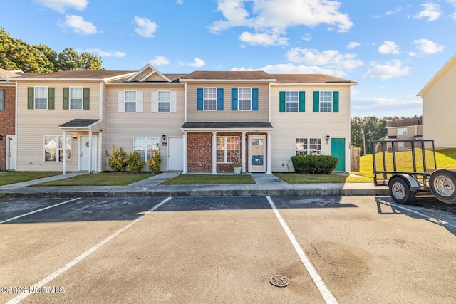 townhome / multi-family property featuring a front lawn