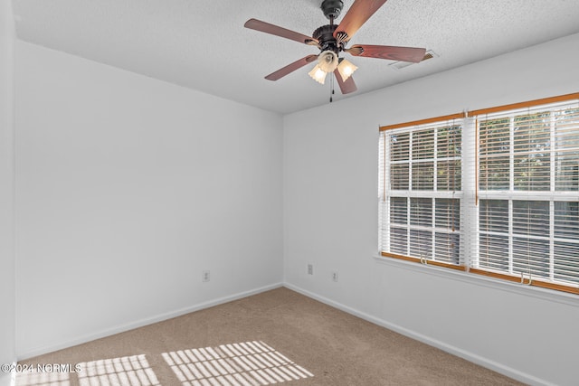 carpeted spare room with a textured ceiling and ceiling fan