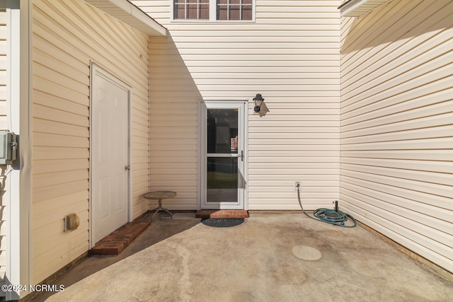 view of exterior entry featuring a patio area