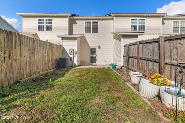 rear view of property featuring a patio, a yard, and central AC unit