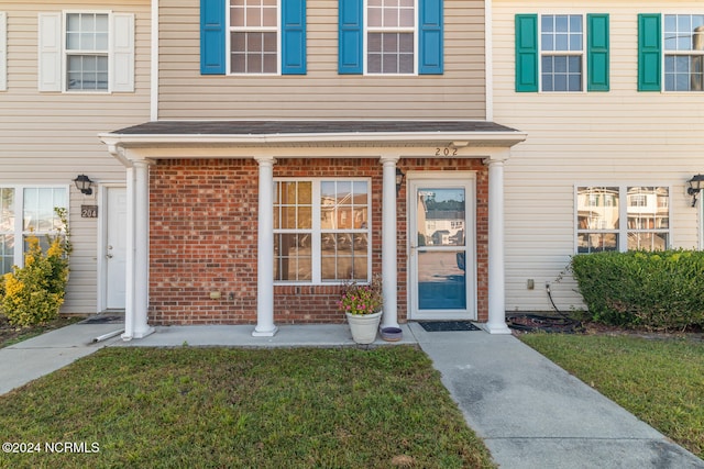 doorway to property featuring a lawn