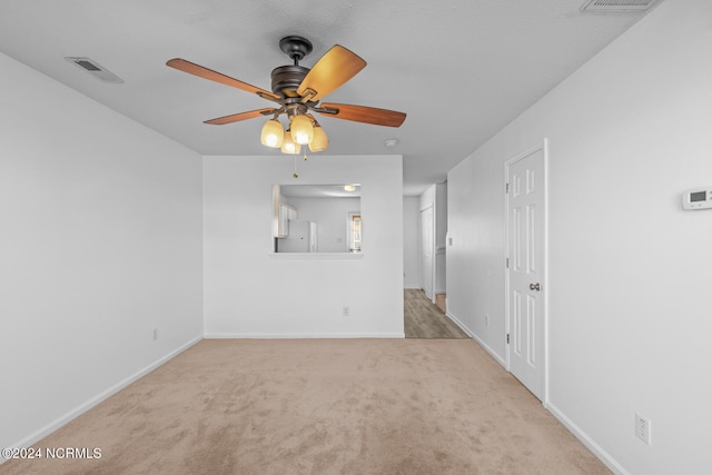 empty room featuring light colored carpet and ceiling fan