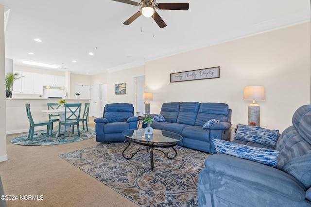 living room with carpet flooring, ornamental molding, and ceiling fan