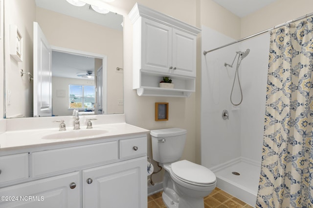 bathroom featuring vanity, toilet, a shower with curtain, and ceiling fan