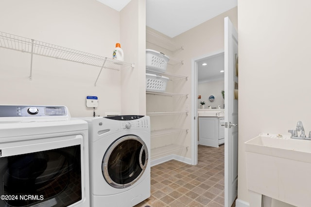 clothes washing area featuring sink and washer and clothes dryer