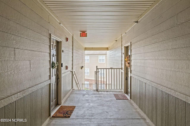 hallway featuring wood walls