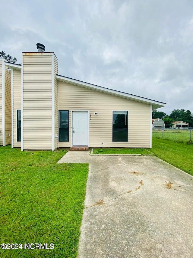 back of property with a patio and a yard