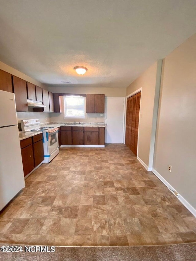 kitchen with white appliances, a textured ceiling, and sink