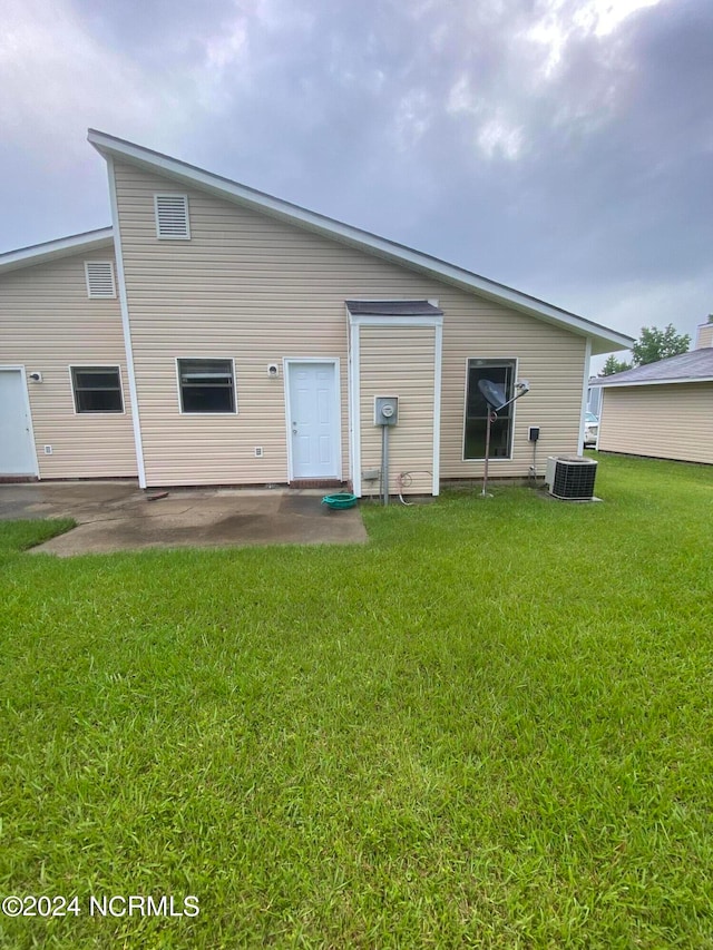 rear view of house featuring a patio area, a lawn, and central AC unit