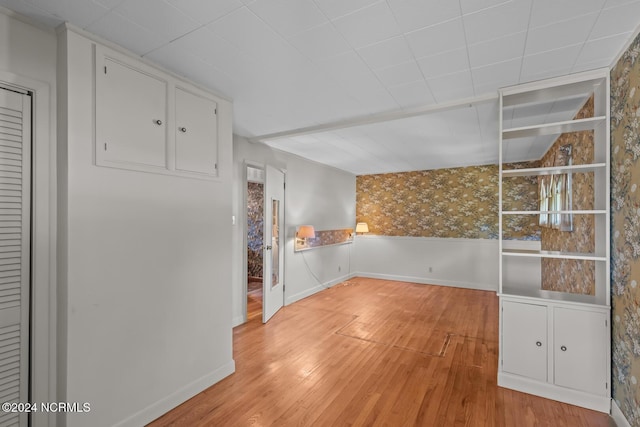 124 N Lisk Dr, Swansboro, NC 28584 - unfurnished room featuring a wainscoted wall, baseboards, wallpapered walls, and light wood finished floors