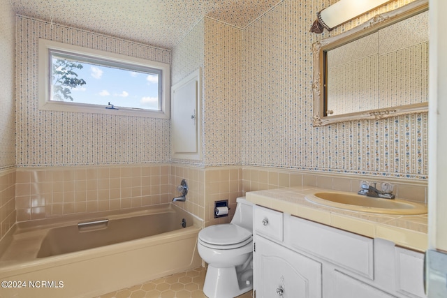 bathroom featuring a bathtub, toilet, and vanity