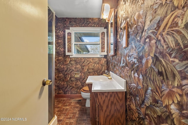 124 N Lisk Dr, Swansboro, NC 28584 - bathroom featuring vanity, baseboards, brick patterned floor, toilet, and wallpapered walls