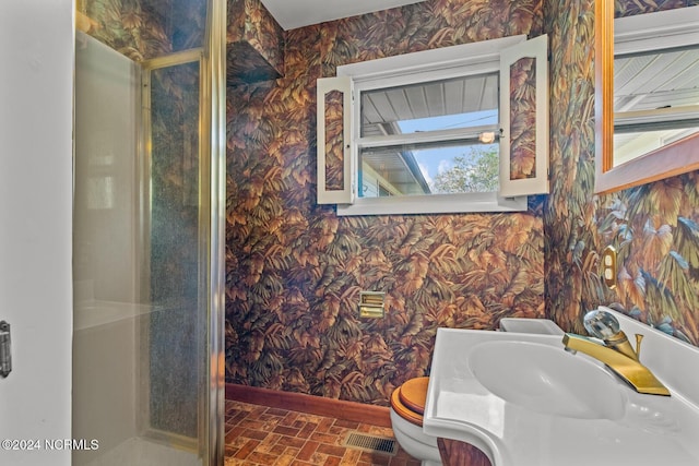 124 N Lisk Dr, Swansboro, NC 28584 - bathroom with a stall shower, baseboards, brick patterned floor, toilet, and wallpapered walls