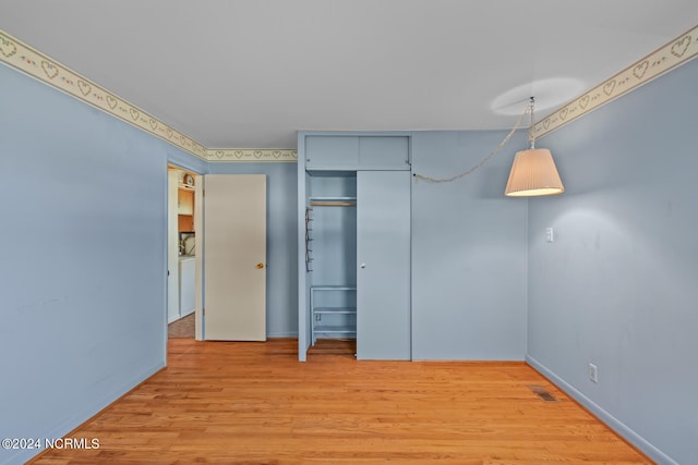 unfurnished bedroom with a closet and light wood-type flooring