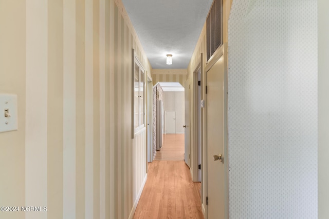 hall featuring a textured ceiling and light wood-type flooring