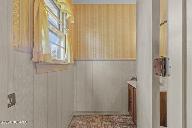 124 N Lisk Dr, Swansboro, NC 28584 - bathroom featuring vanity, wood walls, wainscoting, and wallpapered walls