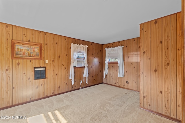 unfurnished room with wooden walls and light colored carpet