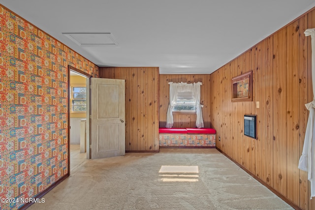 unfurnished bedroom featuring light carpet and wood walls