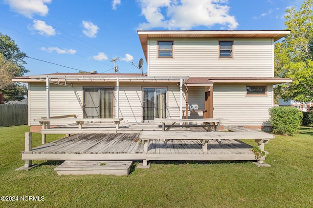 back of property with a deck and a lawn