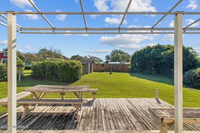 124 N Lisk Dr, Swansboro, NC 28584 - wooden deck featuring a lawn, fence, an outbuilding, and a storage unit