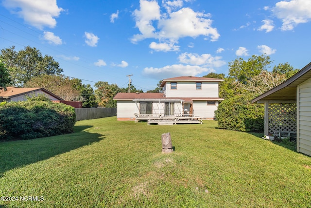 rear view of property with a yard and a deck