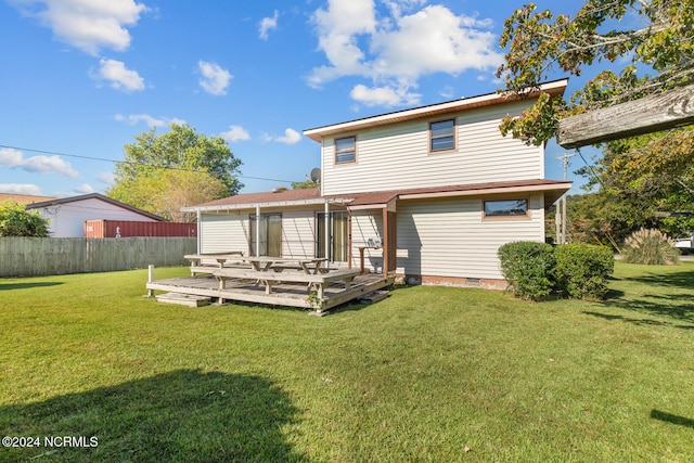 rear view of property featuring a deck and a lawn